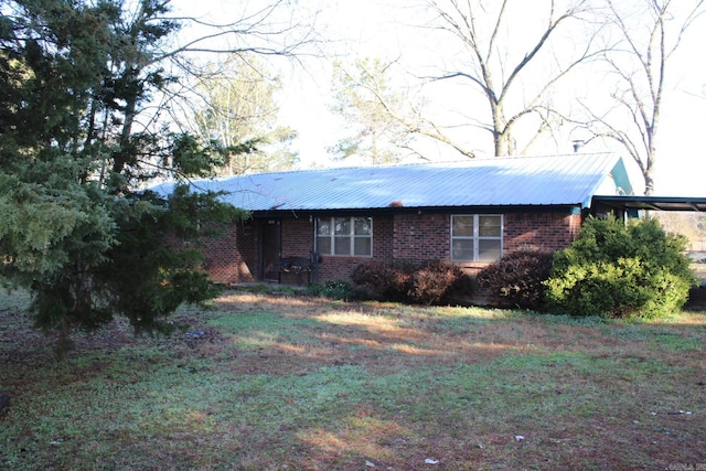 view of property exterior featuring brick siding and metal roof