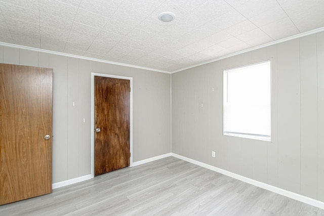 unfurnished room with baseboards, wood finished floors, and ornamental molding