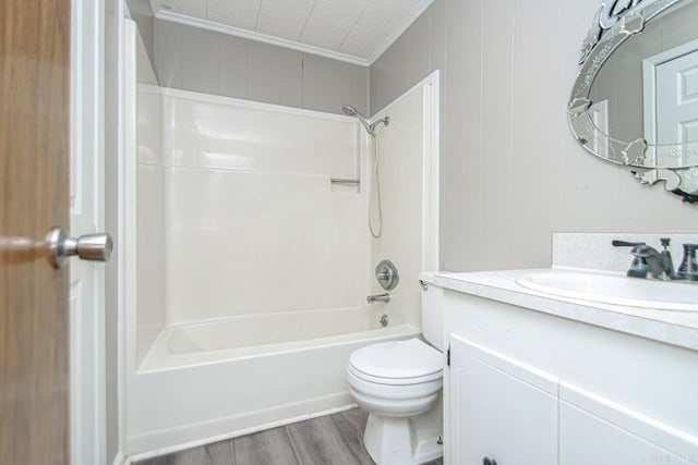 full bath featuring washtub / shower combination, toilet, ornamental molding, wood finished floors, and vanity