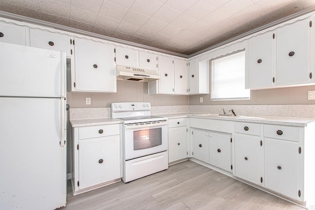 kitchen with under cabinet range hood, white appliances, light countertops, and a sink