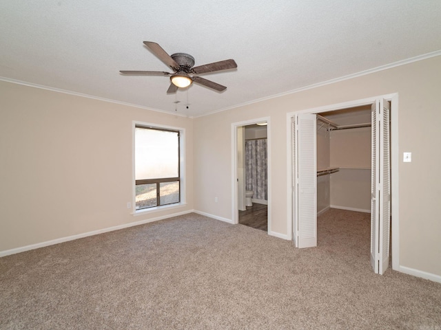 unfurnished bedroom with carpet flooring, ornamental molding, and a spacious closet