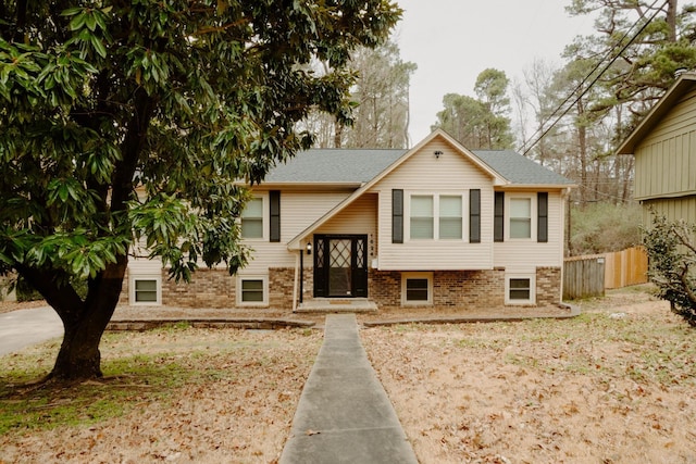 split foyer home with fence and roof with shingles