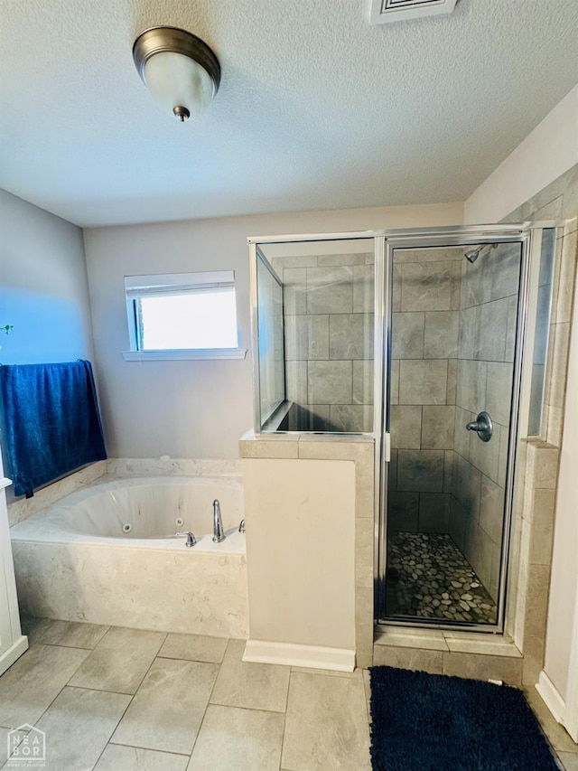 bathroom with a shower stall, a tub with jets, and a textured ceiling