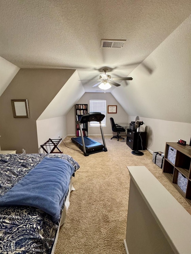 carpeted bedroom with vaulted ceiling, a ceiling fan, visible vents, and a textured ceiling