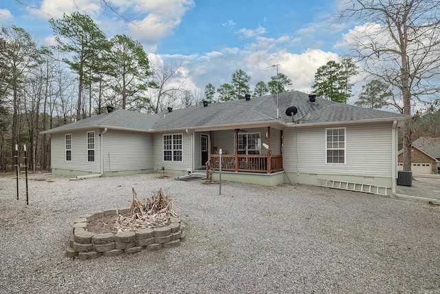 rear view of property featuring crawl space, a fire pit, roof with shingles, and a deck