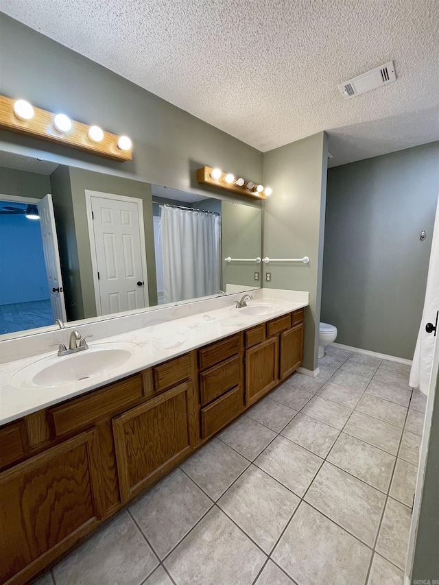 bathroom with tile patterned floors, double vanity, visible vents, and a sink