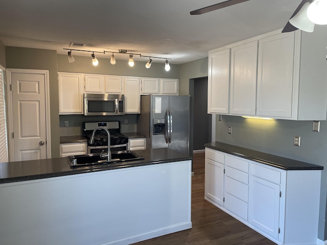 kitchen with dark wood-type flooring, dark countertops, stainless steel appliances, white cabinets, and ceiling fan