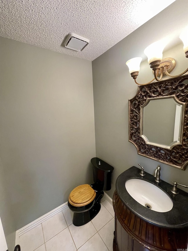 bathroom with tile patterned floors, visible vents, a textured ceiling, baseboards, and vanity