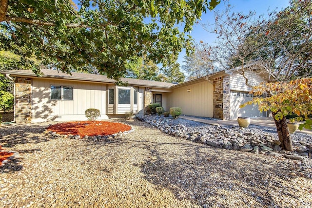 ranch-style home with stone siding and an attached garage