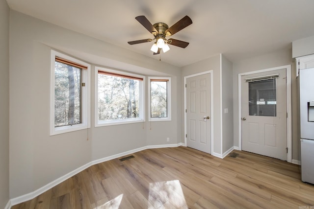 unfurnished bedroom featuring visible vents, multiple windows, and light wood-style floors