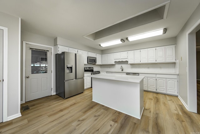 kitchen featuring light wood-style flooring, white cabinets, appliances with stainless steel finishes, and light countertops