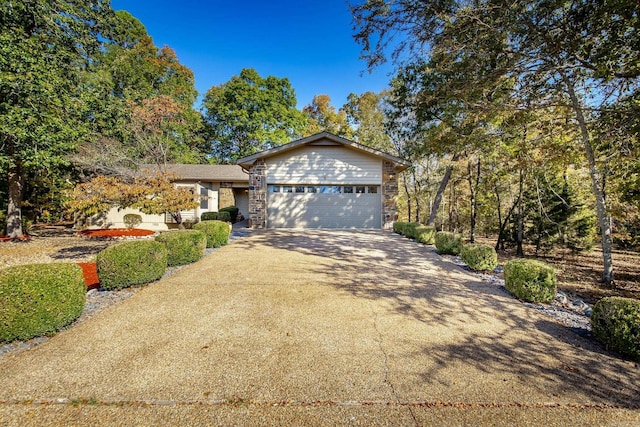 view of front facade with concrete driveway, a garage, and stone siding