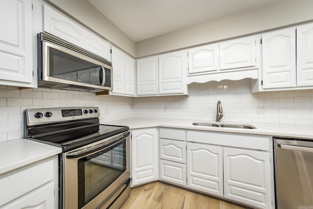 kitchen with a sink, light countertops, tasteful backsplash, and stainless steel appliances