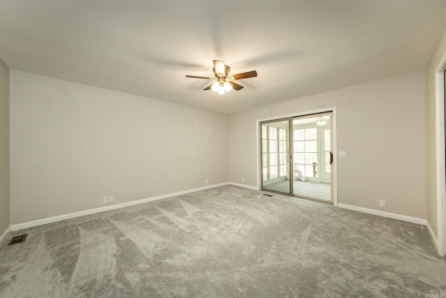 spare room featuring carpet flooring, baseboards, visible vents, and ceiling fan