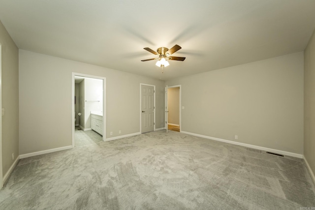 unfurnished bedroom featuring light carpet, ceiling fan, ensuite bath, and baseboards