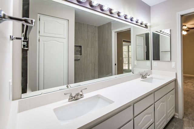 bathroom featuring double vanity, baseboards, and a sink