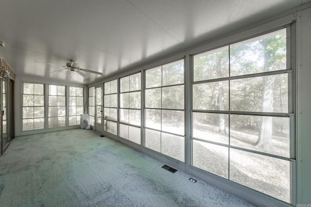 unfurnished sunroom featuring visible vents and a ceiling fan