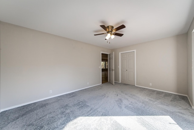 carpeted empty room with baseboards and a ceiling fan