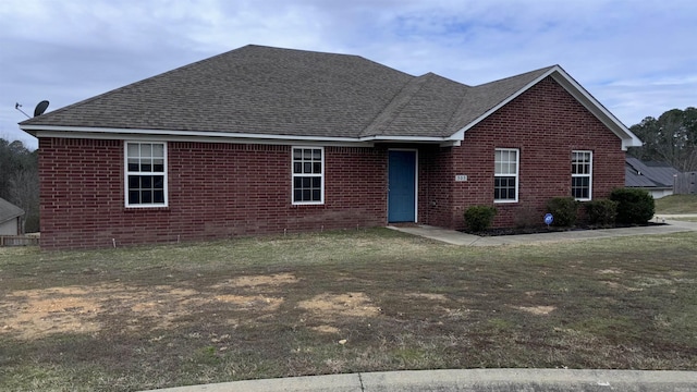 ranch-style house with a front lawn, brick siding, and roof with shingles