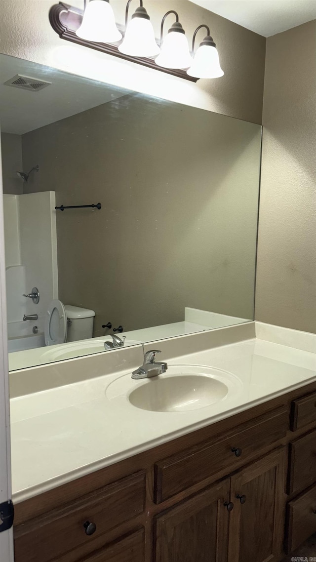 full bathroom featuring vanity, toilet, tub / shower combination, and visible vents