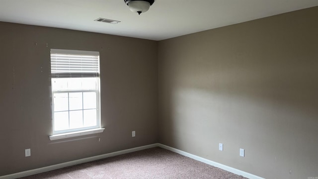 empty room with visible vents, baseboards, and carpet flooring