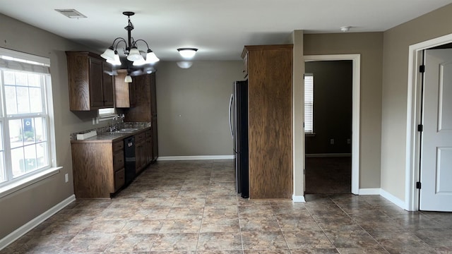 kitchen featuring a sink, baseboards, a notable chandelier, and a healthy amount of sunlight