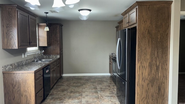 kitchen featuring visible vents, baseboards, hanging light fixtures, black appliances, and a sink