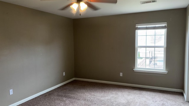 spare room featuring a wealth of natural light, visible vents, baseboards, and a ceiling fan