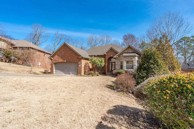 view of front of property featuring brick siding, driveway, and a garage