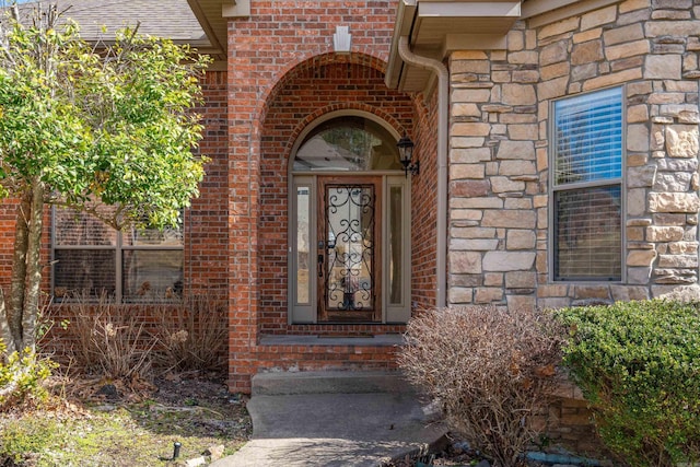 doorway to property featuring brick siding and stone siding