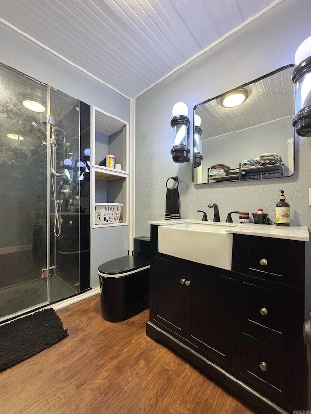 bathroom featuring vanity, a shower stall, wood ceiling, and wood finished floors