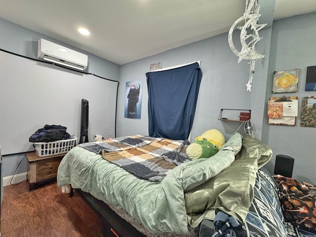 bedroom with wood finished floors and a wall unit AC