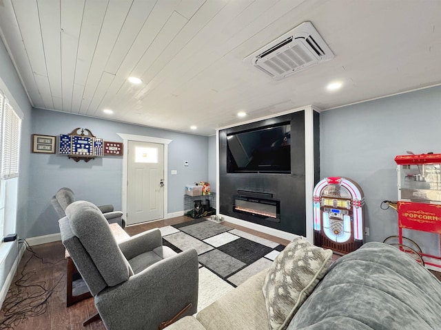 living area with a glass covered fireplace, recessed lighting, baseboards, and wood finished floors