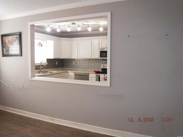 kitchen with tasteful backsplash, crown molding, white cabinets, stainless steel appliances, and a sink