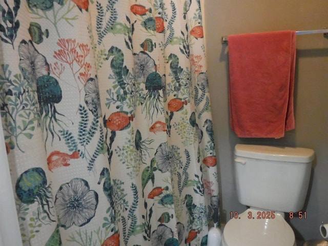 bathroom with a shower with curtain and toilet