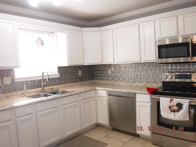 kitchen featuring white cabinetry, backsplash, appliances with stainless steel finishes, and a sink