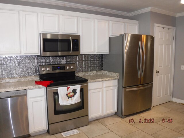 kitchen featuring visible vents, stainless steel appliances, white cabinets, crown molding, and decorative backsplash