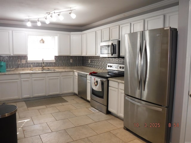 kitchen featuring crown molding, decorative backsplash, white cabinets, stainless steel appliances, and a sink