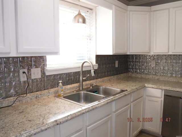 kitchen with stainless steel dishwasher, light countertops, white cabinetry, and a sink