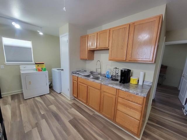 kitchen featuring baseboards, light wood-style floors, and a sink