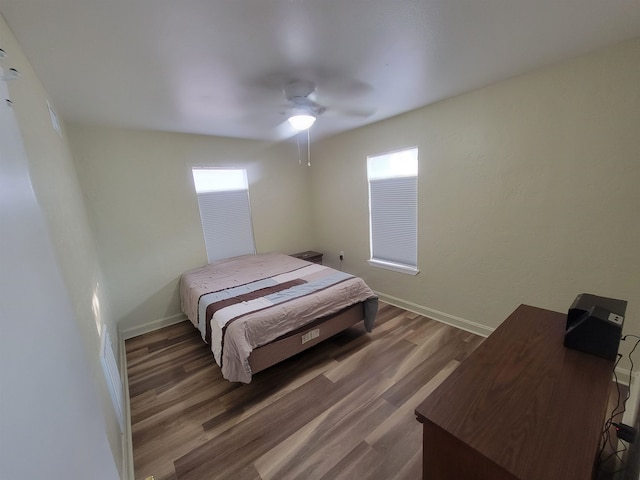 bedroom with ceiling fan, baseboards, and wood finished floors