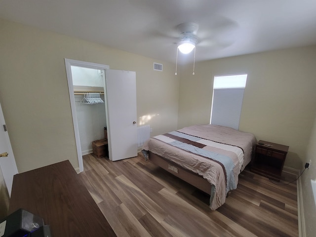 bedroom with a closet, visible vents, a ceiling fan, and wood finished floors