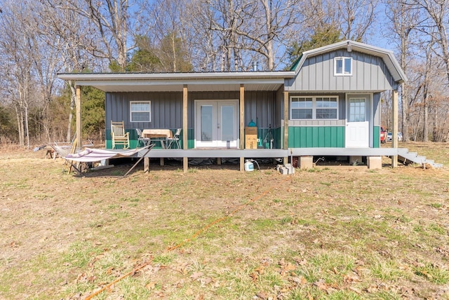 view of front of home featuring french doors, a front yard, and board and batten siding