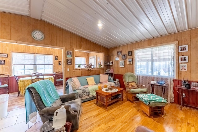 living room featuring lofted ceiling, wood finished floors, and wood walls