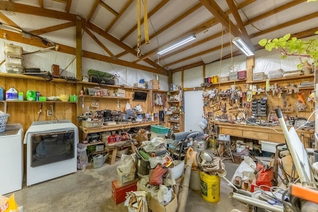 miscellaneous room with concrete floors, lofted ceiling, a workshop area, a garage, and washer and dryer