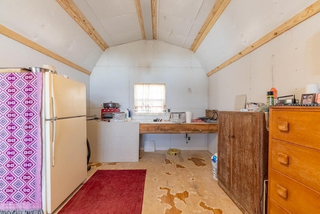 kitchen featuring lofted ceiling and freestanding refrigerator