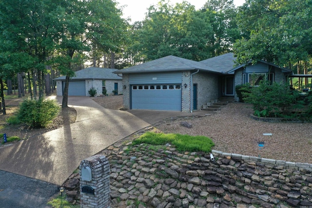 ranch-style house featuring a garage, brick siding, driveway, and a shingled roof