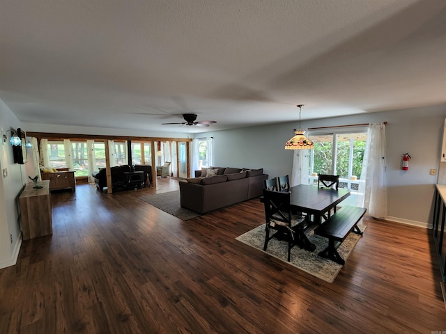 dining room featuring baseboards, dark wood finished floors, and a ceiling fan