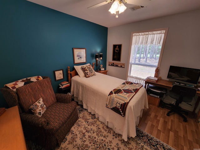 bedroom featuring a ceiling fan, wood finished floors, and visible vents