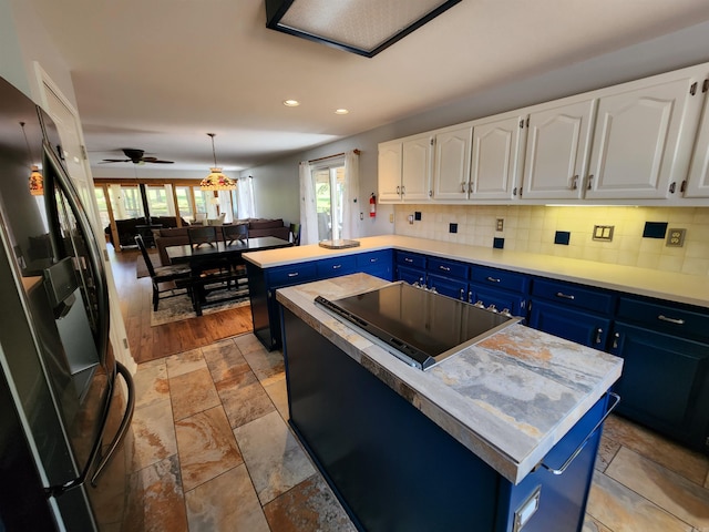 kitchen featuring light countertops, decorative backsplash, white cabinets, black appliances, and blue cabinets